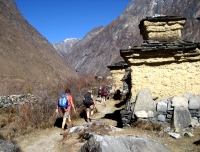 Trekkers walk by Mani wall